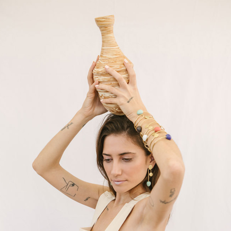 Modelo con brazaletes y pendientes de metal y porcelana colección calder María Torné colores